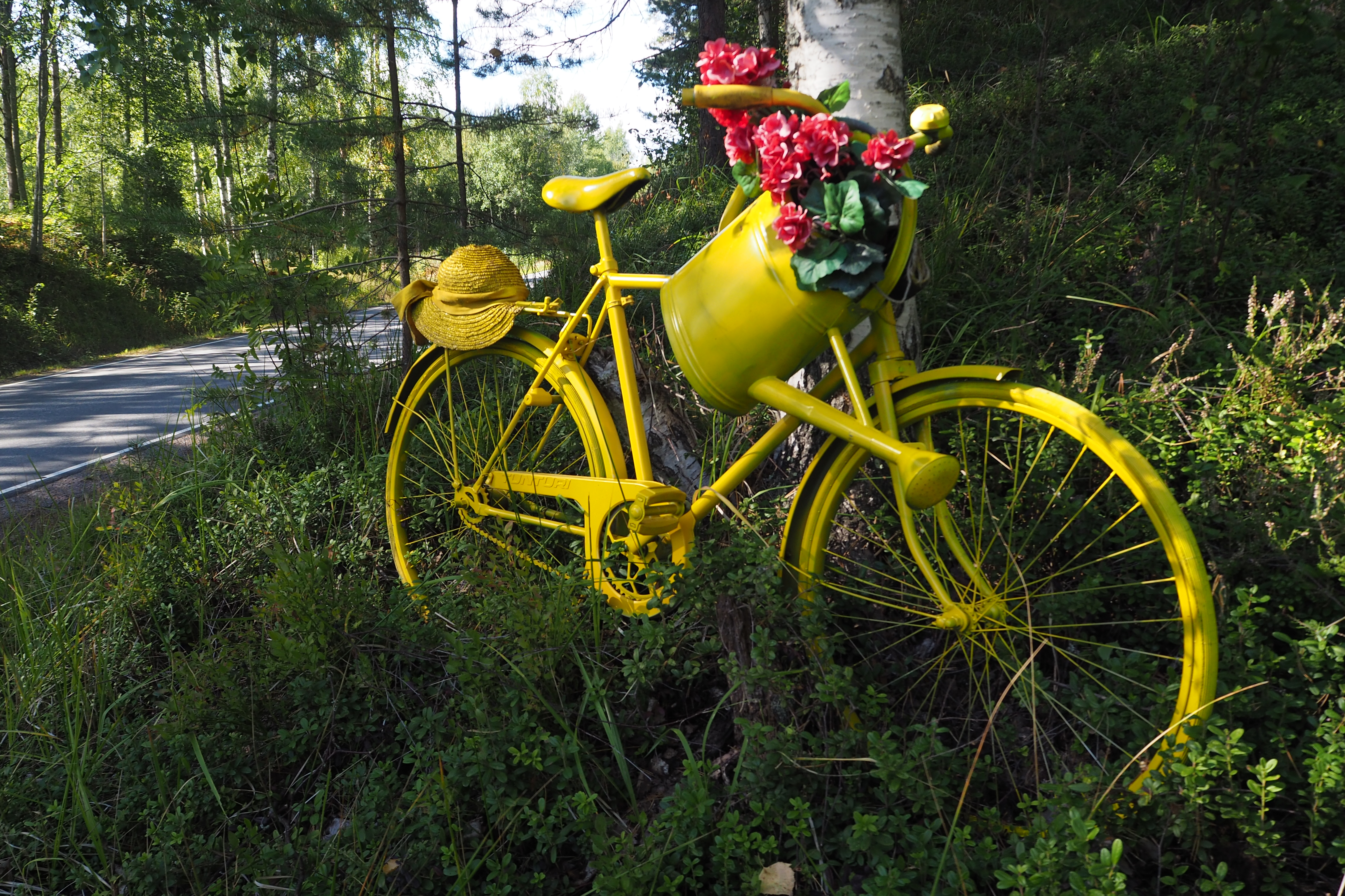A yellow bike with flowers on a basket